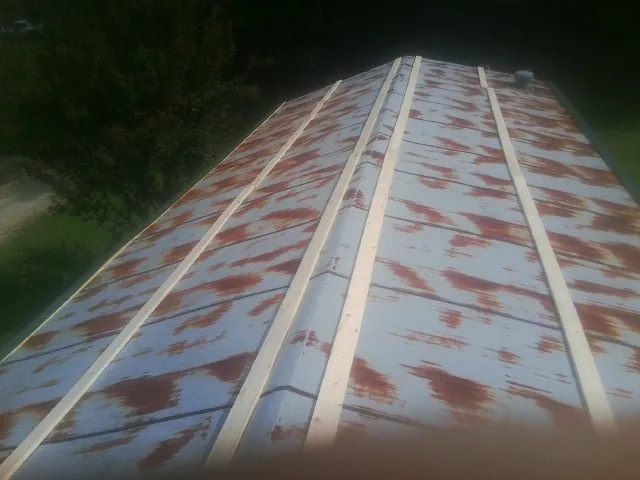 Rusted metal roof panels with new wood purlins before replacement — Storm Damage Roof Repair in Grand Valley by Roofing Brothers