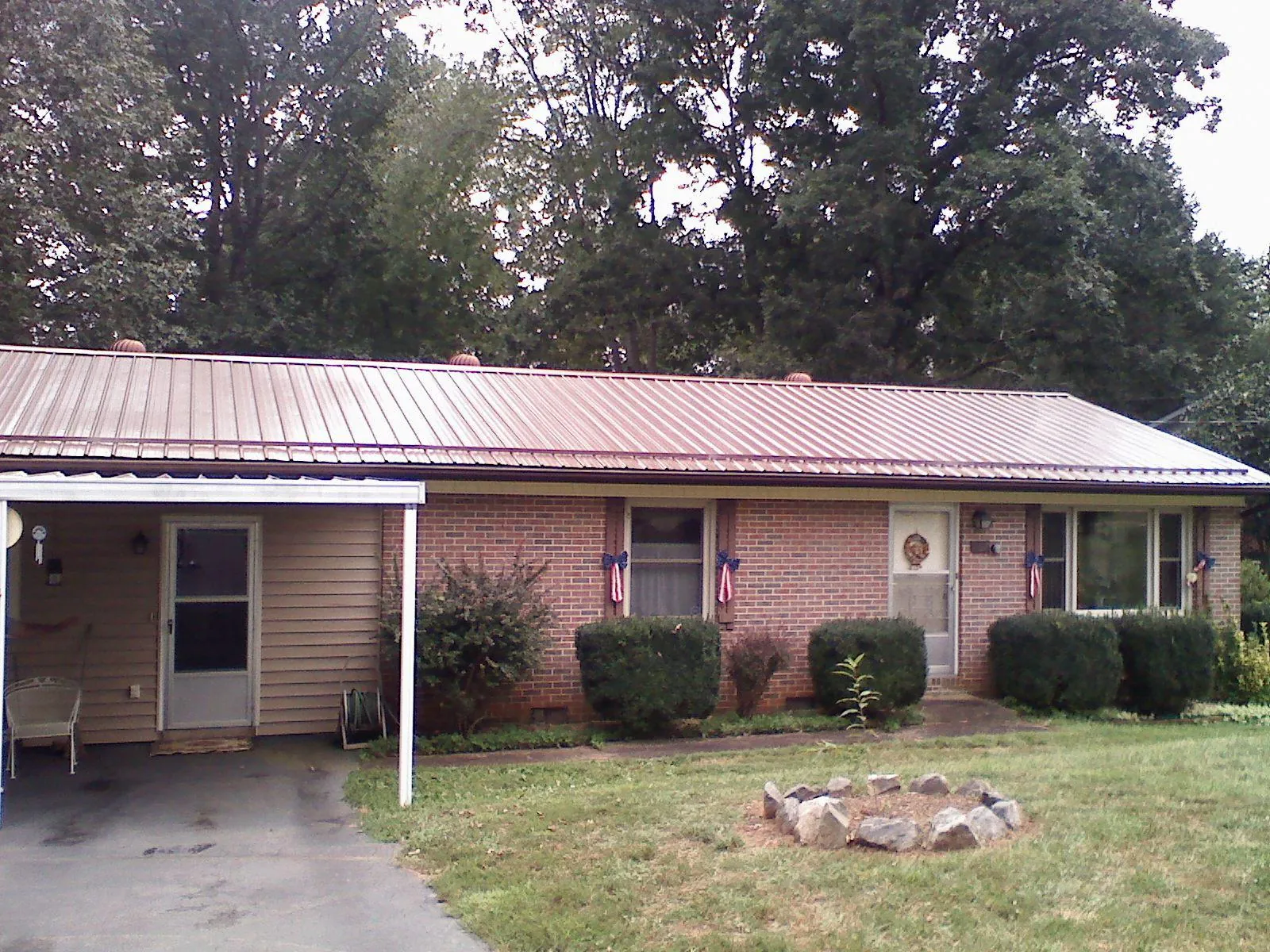Bronze metal roof and carport on a brick ranch home — Roof Repair work by our crew in Grand Valley